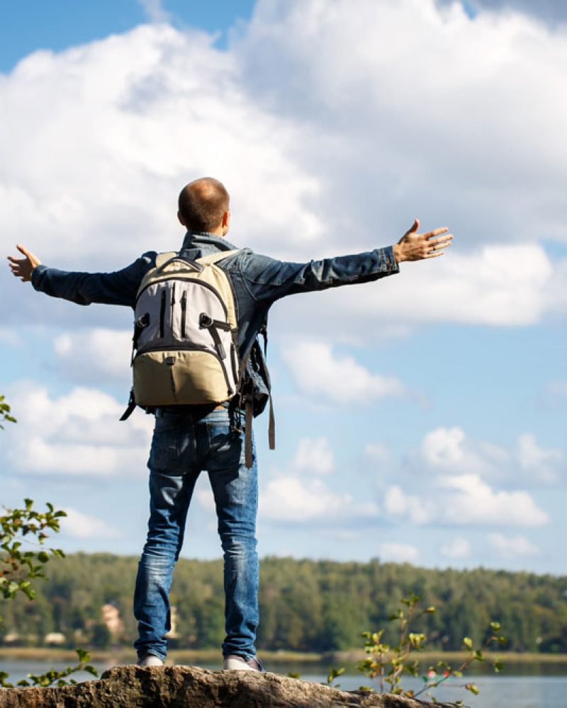 man-standing-green-grass-mountain